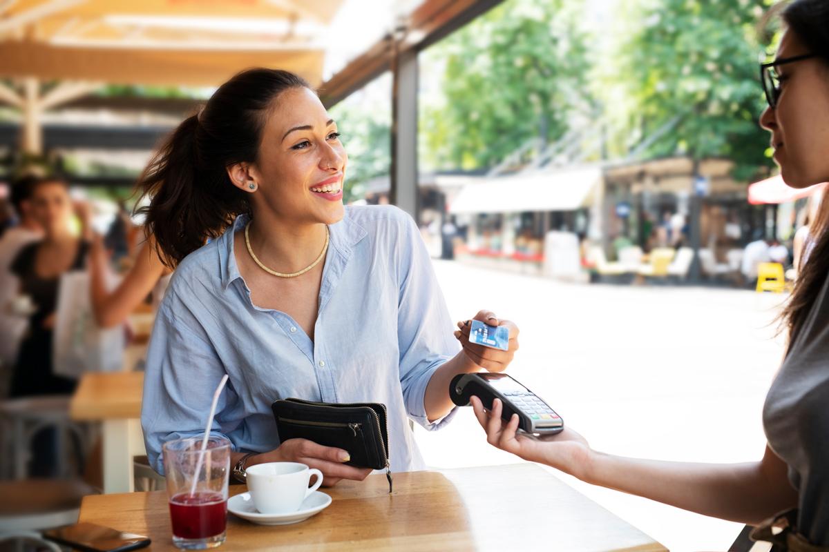 Woman making tap purchase with her credit card.